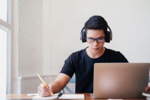 a male student wearing a headphone for online learning